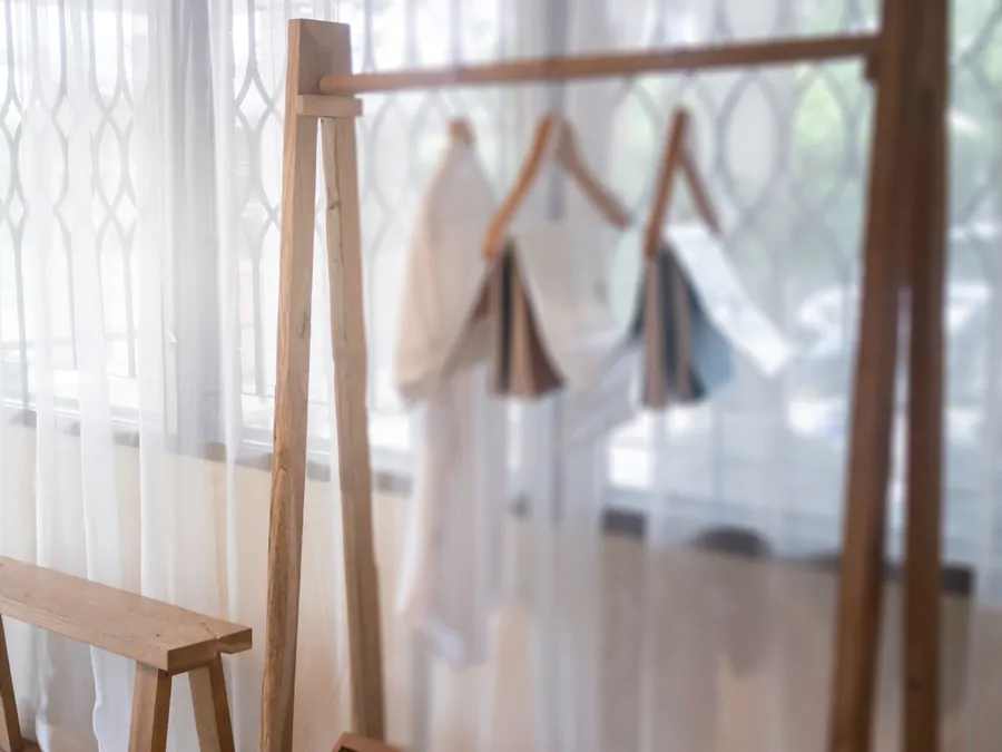 A small studio being set up: a clothing rack of neutral pieces by the window (illustrative photo)